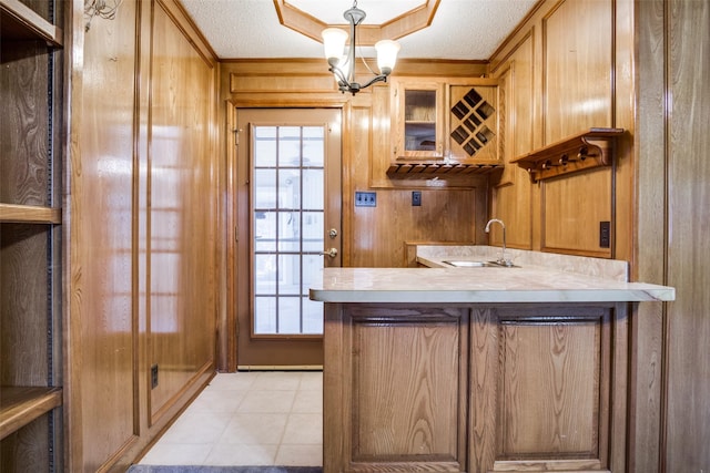 4465 Northern Dancer Dr, Burleson, TX 76028 - indoor wet bar featuring wood walls, a textured ceiling, a chandelier, decorative light fixtures, and light tile patterned floors