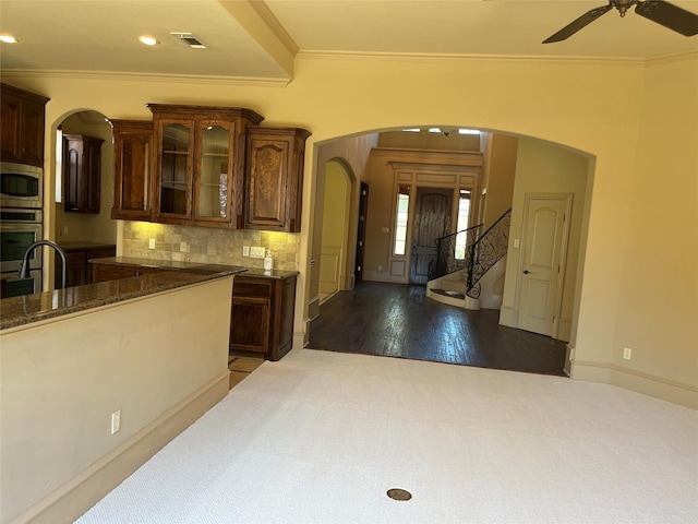6916 Cannon Falls Dr, Plano, TX 75024 - kitchen featuring appliances with stainless steel finishes, ornamental molding, arched walkways, a ceiling fan, and glass insert cabinets