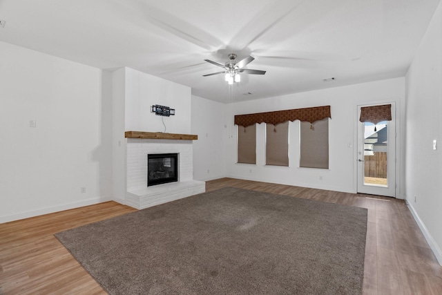 2213 Windy Hill Ln, Waxahachie, TX 75167 - unfurnished living room with wood finished floors, a ceiling fan, baseboards, and a brick fireplace