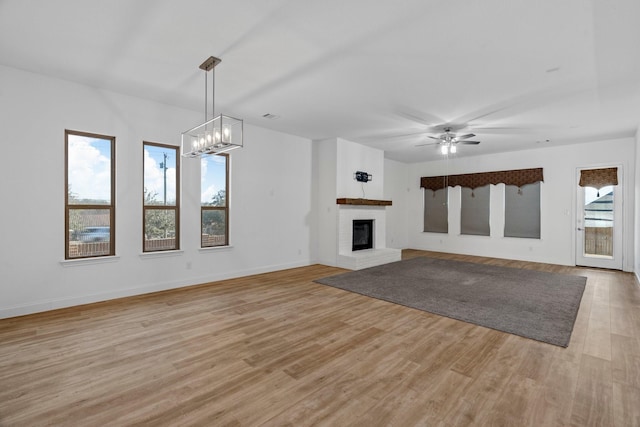 2213 Windy Hill Ln, Waxahachie, TX 75167 - unfurnished living room featuring light wood-style floors, a ceiling fan, baseboards, and a brick fireplace