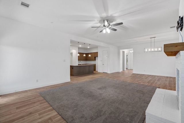 2213 Windy Hill Ln, Waxahachie, TX 75167 - unfurnished living room featuring a ceiling fan, light wood finished floors, baseboards, and a sink
