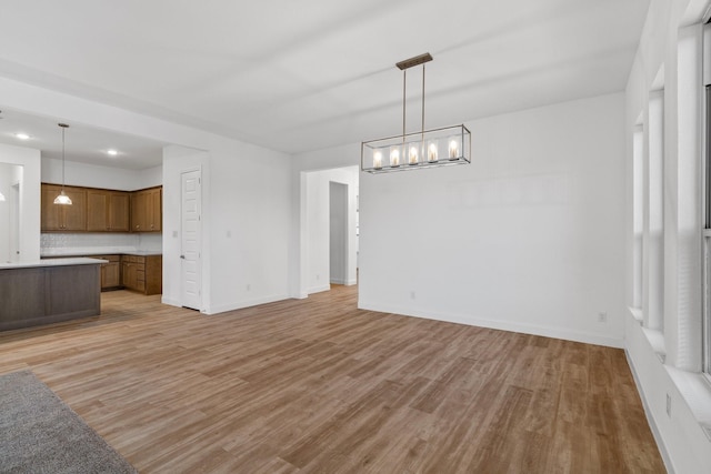2213 Windy Hill Ln, Waxahachie, TX 75167 - unfurnished living room featuring light wood-type flooring, a chandelier, baseboards, and recessed lighting