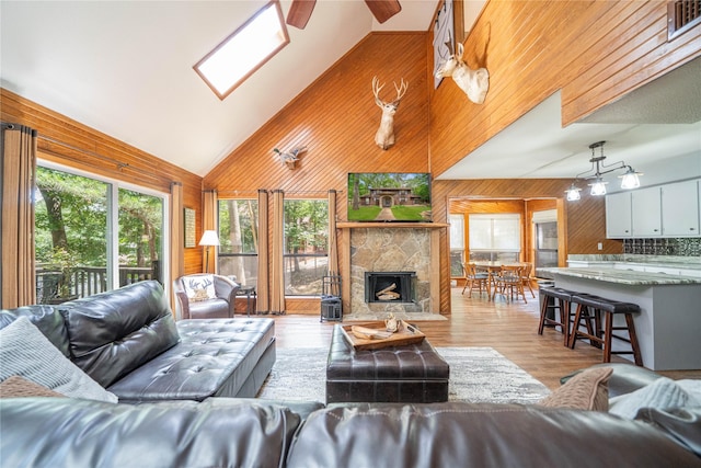 203 King Laurence, Scroggins, TX 75480 - living area featuring wood walls, high vaulted ceiling, wood finished floors, ceiling fan, and a stone fireplace