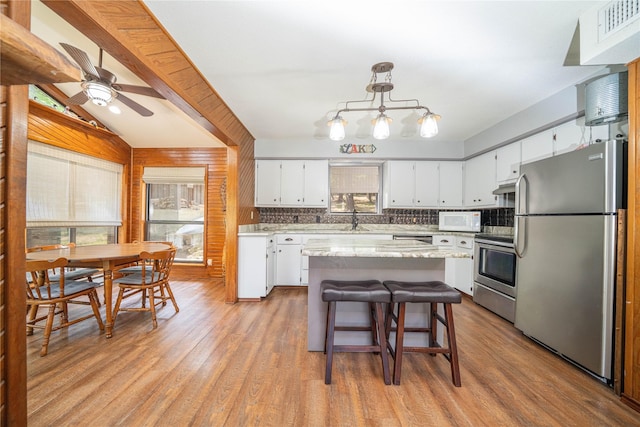 203 King Laurence, Scroggins, TX 75480 - kitchen featuring appliances with stainless steel finishes, light wood-type flooring, white cabinetry, a ceiling fan, and a center island