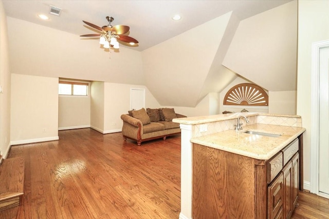 2221 Southern Oaks Dr, Cedar Hill, TX 75104 - kitchen with a sink, light stone countertops, a ceiling fan, wood finished floors, and brown cabinetry