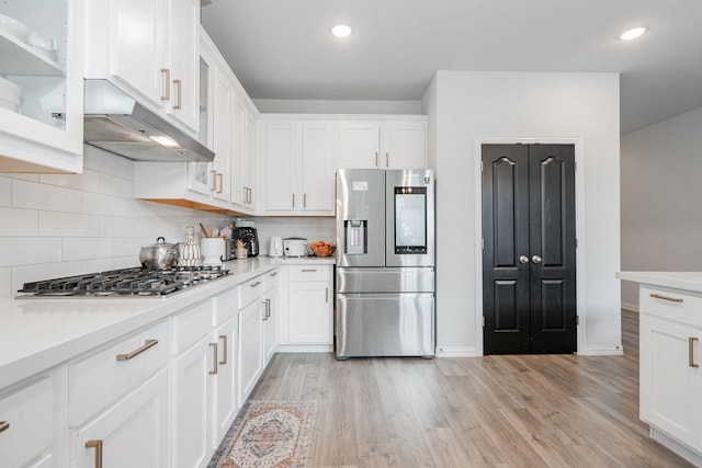 2702 Willow Ln, Melissa, TX 75454 - kitchen with stainless steel appliances, white cabinets, light wood-type flooring, light countertops, and glass insert cabinets