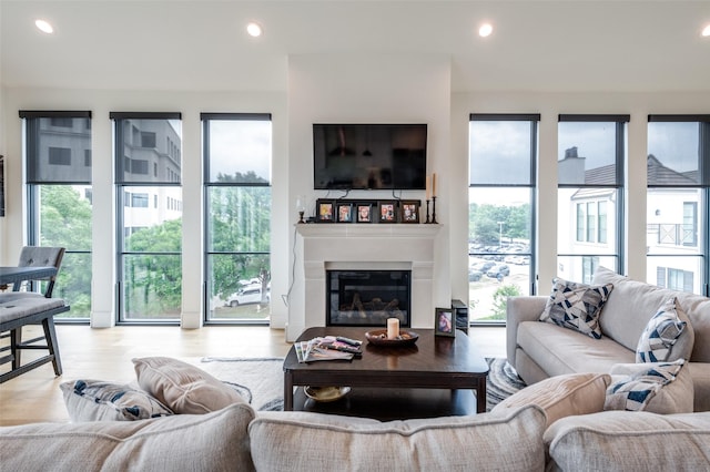 5270 Town And Country Unit 326, Frisco, TX 75034 - living area with wood finished floors, a glass covered fireplace, and recessed lighting