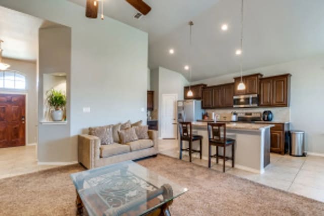 11520 Starlight Ranch Trl, Fort Worth, TX 76052 - living area featuring a ceiling fan, light carpet, high vaulted ceiling, light tile patterned floors, and baseboards
