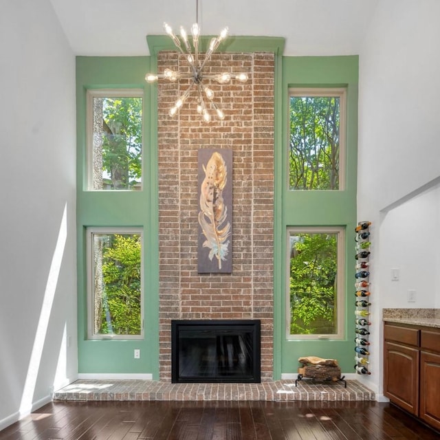 3227 Elizabeth St, Dallas, TX 75204 - living room with a chandelier, a high ceiling, dark wood-style flooring, and a fireplace