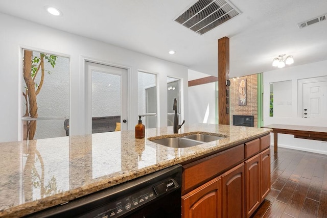 3227 Elizabeth St, Dallas, TX 75204 - kitchen with black dishwasher, dark wood-style floors, a brick fireplace, light stone countertops, and brown cabinets