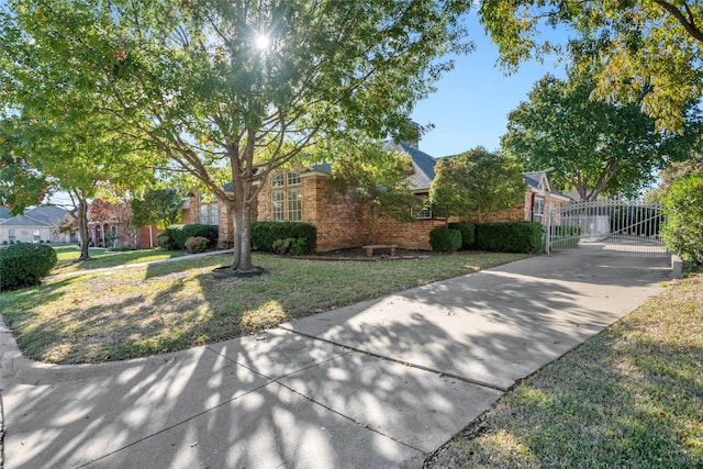 6705 Rolling Hills Dr, North Richland Hills, TX 76182 - obstructed view of property with brick siding, driveway, and a gate