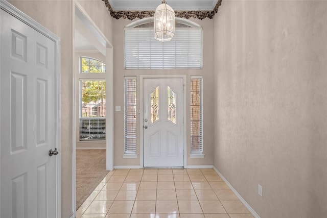 6705 Rolling Hills Dr, North Richland Hills, TX 76182 - foyer featuring a chandelier, baseboards, light tile patterned floors, crown molding, and light carpet