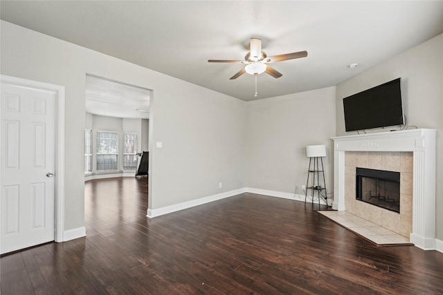 313 Wallford Ln, Lake Dallas, TX 75065 - unfurnished living room with a ceiling fan, a tiled fireplace, wood finished floors, and baseboards
