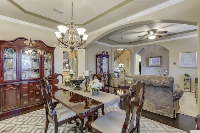 2724 Ferncrest Trl, Mansfield, TX 76063 - dining space with arched walkways, a tray ceiling, a chandelier, wood finished floors, and crown molding