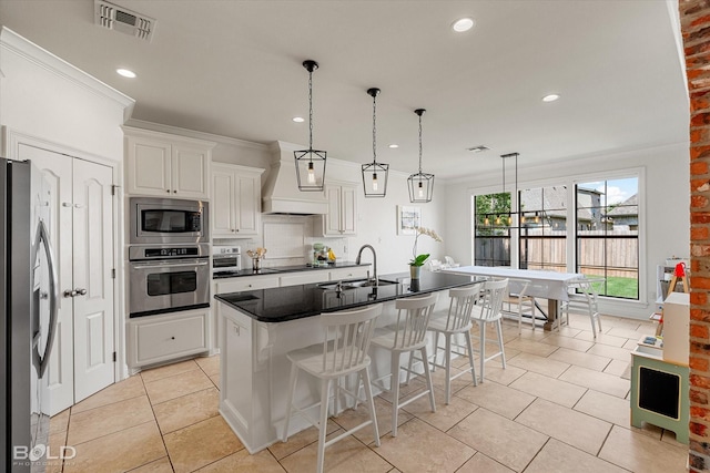 9961 Loveland Ct, Shreveport, LA 71106 - kitchen with appliances with stainless steel finishes, a sink, premium range hood, dark countertops, and a breakfast bar area