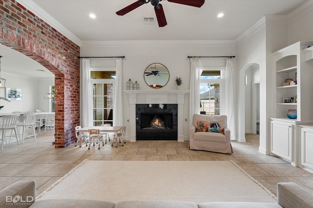 9961 Loveland Ct, Shreveport, LA 71106 - living room featuring ceiling fan, arched walkways, a lit fireplace, ornamental molding, and recessed lighting