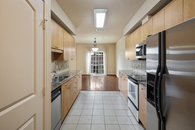 6624 Federal Hall St, Plano, TX 75023 - kitchen with stainless steel appliances, light brown cabinetry, backsplash, and a sink