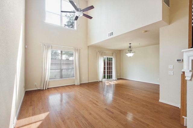 6624 Federal Hall St, Plano, TX 75023 - unfurnished living room featuring light wood-type flooring, ceiling fan, a high ceiling, baseboards, and a fireplace