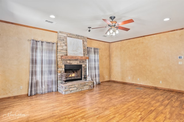 1321 Anniston Ave, Shreveport, LA 71105 - unfurnished living room featuring wood finished floors, ceiling fan, a stone fireplace, crown molding, and baseboards