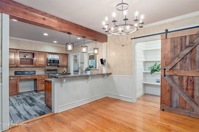 1321 Anniston Ave, Shreveport, LA 71105 - kitchen with appliances with stainless steel finishes, brown cabinetry, light wood-style floors, a breakfast bar area, and a barn door