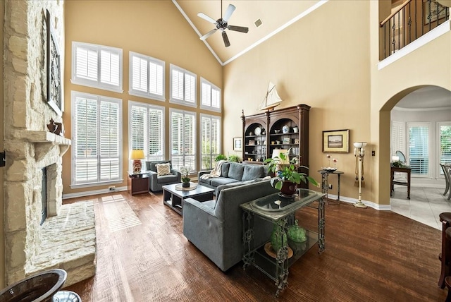 1304 Salsbury Cir, Murphy, TX 75094 - living room with high vaulted ceiling, arched walkways, ceiling fan, a fireplace, and ornamental molding