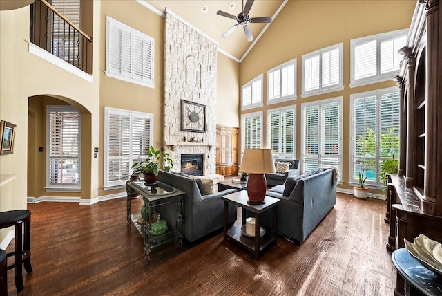 1304 Salsbury Cir, Murphy, TX 75094 - living room with a ceiling fan, high vaulted ceiling, wood finished floors, a stone fireplace, and arched walkways