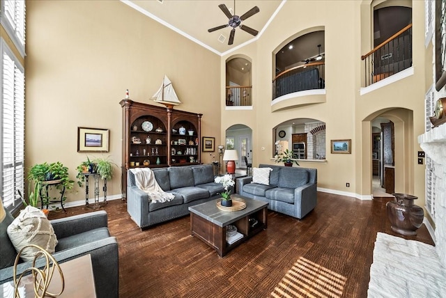 1304 Salsbury Cir, Murphy, TX 75094 - living area featuring a towering ceiling, a ceiling fan, wood finished floors, ornamental molding, and arched walkways