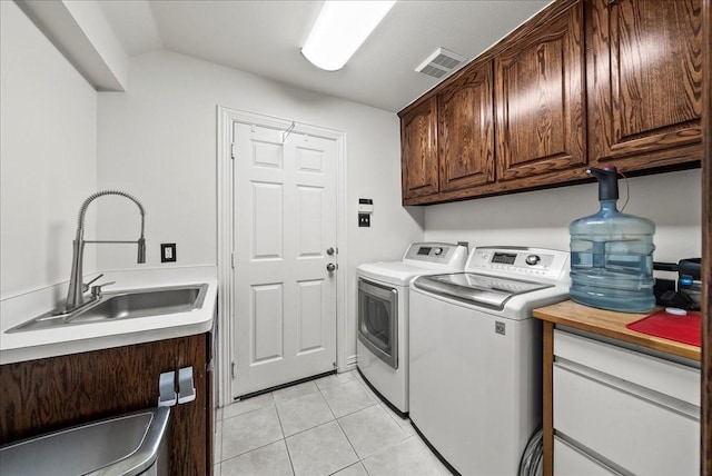 1304 Salsbury Cir, Murphy, TX 75094 - laundry room featuring cabinet space, washing machine and clothes dryer, and light tile patterned floors