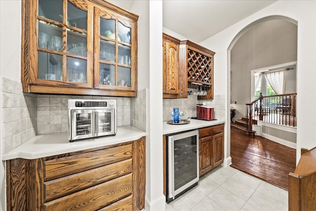 1304 Salsbury Cir, Murphy, TX 75094 - indoor dry bar with beverage cooler, light tile patterned floors, decorative backsplash, and arched walkways