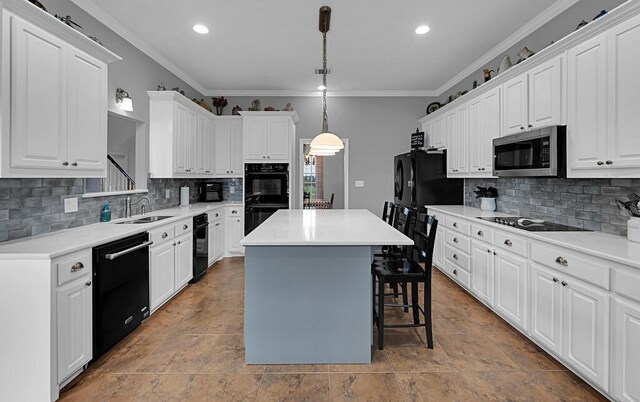 804 Heritage Pkwy, Axtell, TX 76624 - kitchen featuring black appliances, a sink, a kitchen island, a breakfast bar, and ornamental molding
