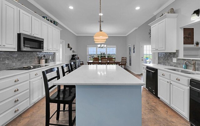804 Heritage Pkwy, Axtell, TX 76624 - kitchen with black appliances, a sink, a center island, backsplash, and white cabinetry