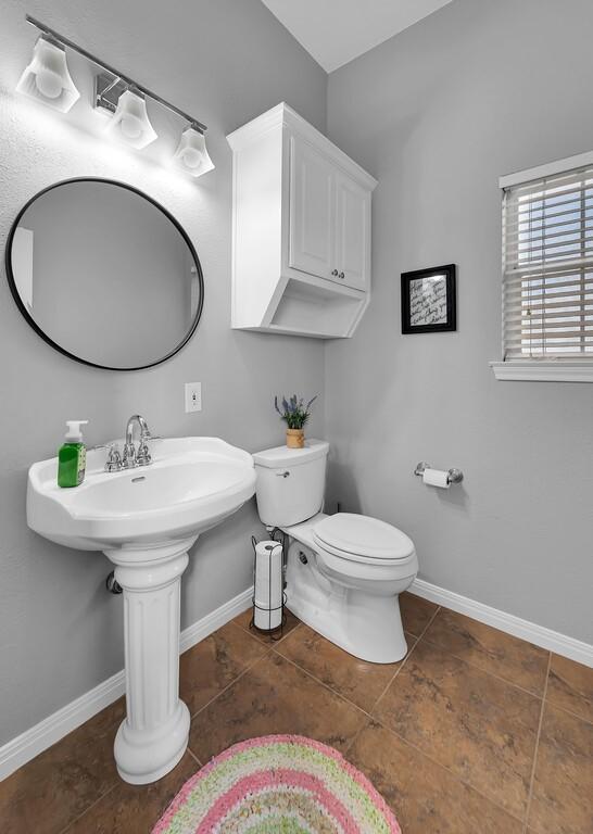 804 Heritage Pkwy, Axtell, TX 76624 - bathroom with toilet, tile patterned floors, baseboards, and a sink