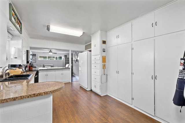 2202 Belmeade Ave, Brownwood, TX 76801 - kitchen featuring a sink, white fridge with ice dispenser, dark wood-style flooring, white cabinetry, and stainless steel microwave