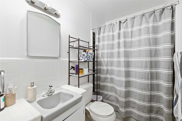 2202 Belmeade Ave, Brownwood, TX 76801 - full bathroom with vanity, toilet, a shower with shower curtain, and tile walls
