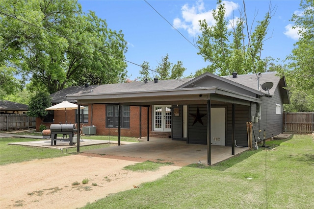 2202 Belmeade Ave, Brownwood, TX 76801 - rear view of house with dirt driveway, french doors, central air condition unit, an attached carport, and roof with shingles