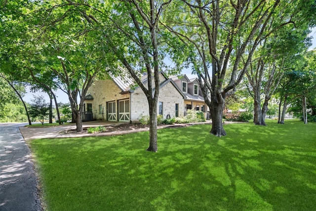 1814 Stacy Rd, Fairview, TX 75069 - view of front of home featuring a front lawn, stone siding, an attached garage, and driveway