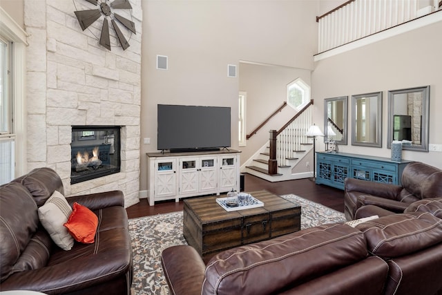 1814 Stacy Rd, Fairview, TX 75069 - living area with a towering ceiling, dark wood-type flooring, stairs, a stone fireplace, and baseboards