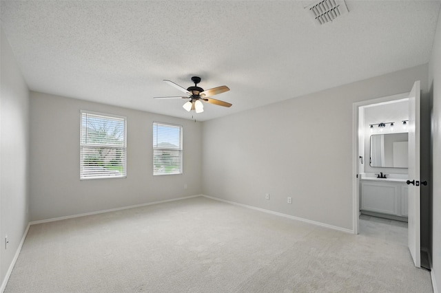 2922 Sheridan Ln, Wylie, TX 75098 - unfurnished bedroom with light colored carpet, baseboards, connected bathroom, a textured ceiling, and a sink