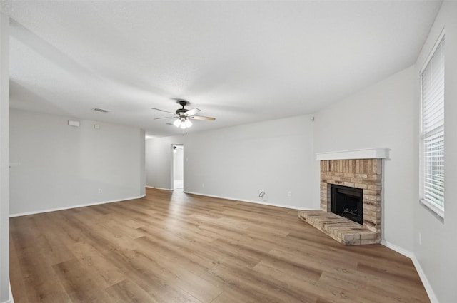 2922 Sheridan Ln, Wylie, TX 75098 - unfurnished living room with a ceiling fan, a brick fireplace, light wood finished floors, and baseboards
