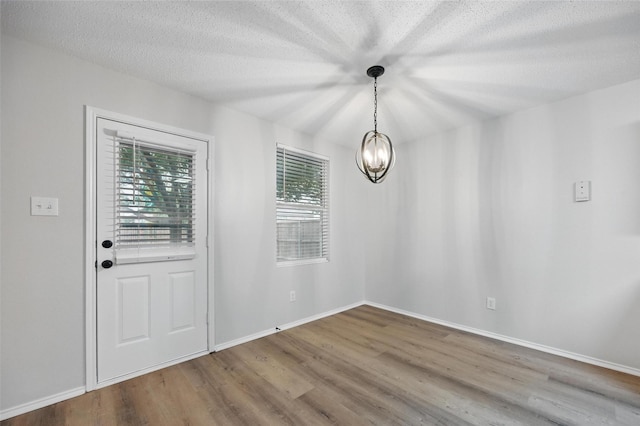 2922 Sheridan Ln, Wylie, TX 75098 - unfurnished dining area with wood finished floors, baseboards, a textured ceiling, and a chandelier
