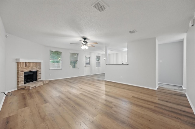 2922 Sheridan Ln, Wylie, TX 75098 - unfurnished living room with a ceiling fan, wood finished floors, a textured ceiling, a fireplace, and baseboards