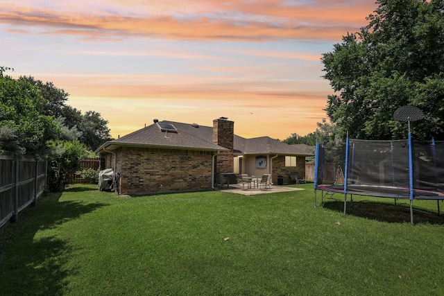 9 Chimney Rock Dr, Trophy Club, TX 76262 - back of house with a trampoline, a patio area, a chimney, brick siding, and roof with shingles