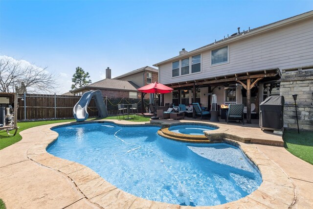 225 Redhead Dr, Little Elm, TX 75068 - view of pool featuring a patio area, a water slide, a fenced backyard, a pool with connected hot tub, and ceiling fan