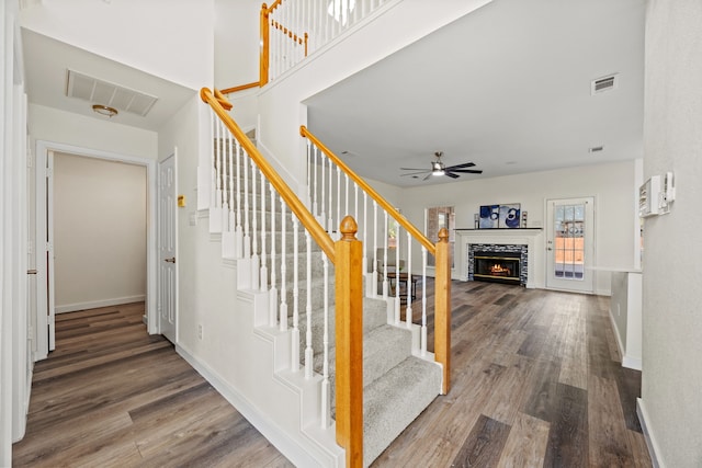 8901 Elbe Trl, Fort Worth, TX 76118 - stairs with wood finished floors, ceiling fan, a warm lit fireplace, and baseboards
