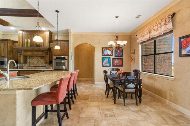 120 Trail Rdg, Weatherford, TX 76087 - kitchen featuring a sink, appliances with stainless steel finishes, arched walkways, backsplash, and light stone counters
