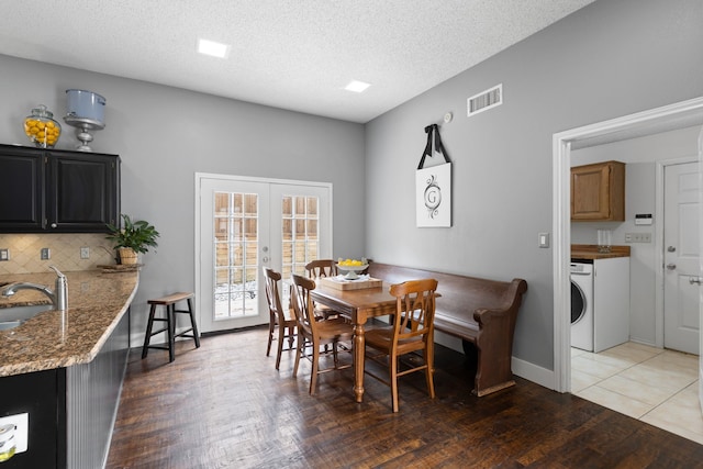2304 Colleen Ct, Carrollton, TX 75007 - dining room featuring wood finished floors, french doors, a textured ceiling, and washer / clothes dryer