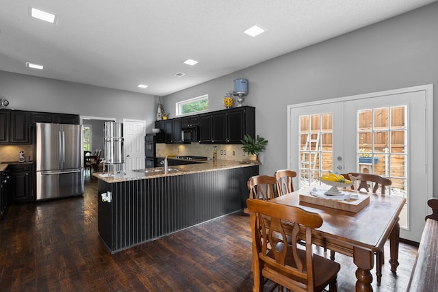 2304 Colleen Ct, Carrollton, TX 75007 - kitchen featuring freestanding refrigerator, black microwave, dark cabinetry, tasteful backsplash, and recessed lighting