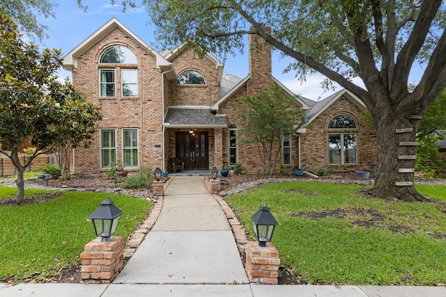 2304 Colleen Ct, Carrollton, TX 75007 - traditional home featuring brick siding, a chimney, a front yard, and roof with shingles