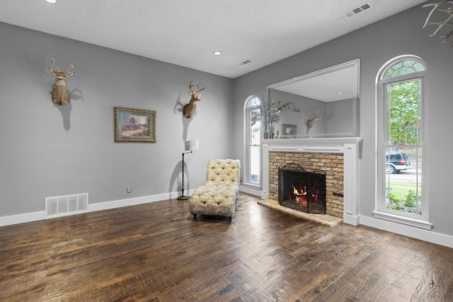 2304 Colleen Ct, Carrollton, TX 75007 - living area with a brick fireplace, wood finished floors, a textured ceiling, and recessed lighting