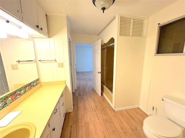 202 Powell Rd, Weatherford, TX 76088 - full bath with wood finished floors, a shower with shower door, toilet, vanity, and a textured ceiling